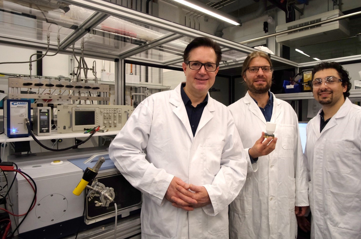 Spectroelectrochemistry laboratory at the Department of Chemistry and Pharmacy, Friedrich-Alexander-Universität Erlangen-Nürnberg. From right to left: Prof. Dr. Jörg Libuda, Dr. Olaf Brummel presenting an infrared spectroscopy cell, and Firas Faisal (PhD student).